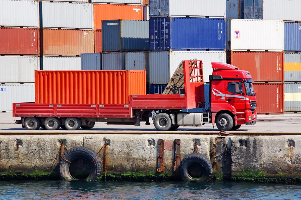 Camión cargando contenedores de mercancías en un puerto